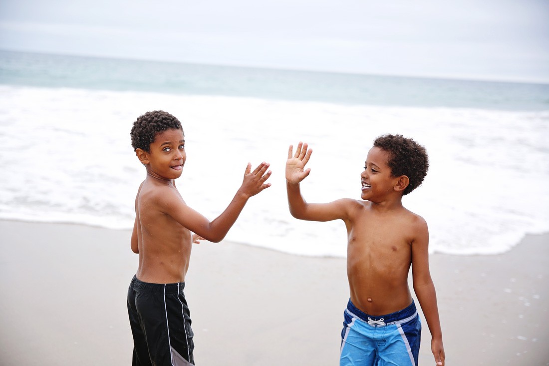 multiracial children on beach, playing with friends